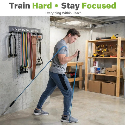 Man using gym gear next to 8 Hook Wall Mount Home Gym Organizer Rack for Barbells Resistance Bands Jump Ropes Foam Rollers Belts