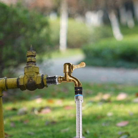 Outdoor garden faucet connected to a hose with Three Quarter Inch Garden Hose Quick Connect Fittings, side view
