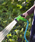 Person using Ultra Lightweight Rubber Farm Hose For Ranch Work Three Quarter Inch By Fifteen Feet, 500 PSI in a garden setting