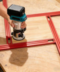 Heavy Duty Adjustable Router Jig For Cutting Boards with red aluminum frame and router in use on a wooden surface.