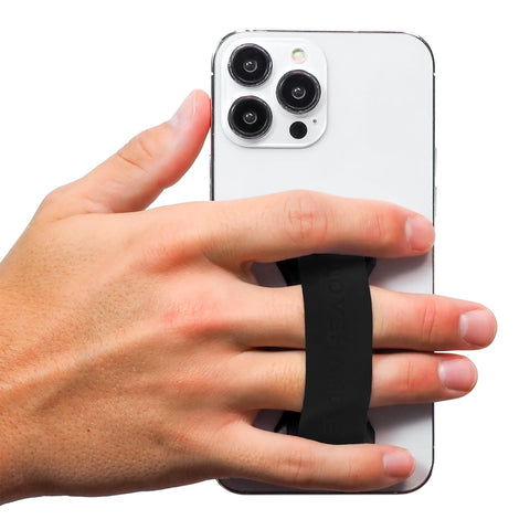 Hand holding smartphone with Premium Silicone Phone Strap Grip With Magnetic Mount And Kickstand For Smartphones And Tablets One Handed Texting And Selfies Waterproof And Easy To Clean Black On Black Base