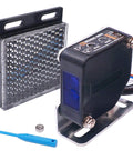 Indoor Wall Mounted Photoelectric Beam Sensor with dual voltage, retroreflective proximity switch, and green LED indicator, shown with a reflector.