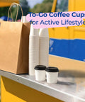 To-go display with stacked paper cups and two 100 Pack 4 Oz Disposable Coffee Cups With Lids For Travel And Office Leak Proof