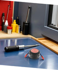 Automatic Aerosol Fire Extinguisher Patch Offering A No Sweat Setup For Quick Flare Zapping On Car Dashboards Wall Outlets And Power Strips A Slick Round Safety Tab That Nests Right Into Tight Squeezes on a workbench with tools.