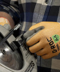 DX Technology Cut Resistant Work Glove With Polyurethane Palm ANSI A4 Protection handling a power tool, showing grip and protection.