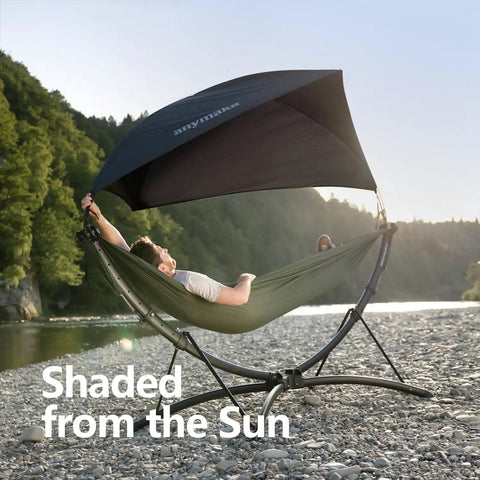 Set Up In 3 Seconds Adjustable Portable Aluminum Hammock Stand For Outdoors with canopy on rocky beach, man relaxing.