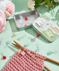 Flower Stitch Markers Set Of 18 In 9 Colors For Knitting Crochet And Weaving With Acrylic Markers And Stainless Steel Wire Perfect For Jewelry Making And Craft Projects Easy To See And Slide On For DIY Makers in tin box with knitting project