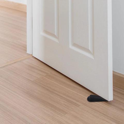 2Pcs Black Rubber Door Stopper Wedge With Antislip Surface for bedroom or office use shown under white door on wooden floor