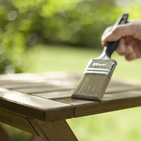 Applying Top Shelf Exterior Wood Stain For Outdoor Decks And Patios Waterproof Sealant With Superior UV Resistance 500 Ml Can on wooden table.