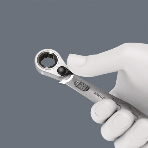 Close-up of hand holding Joker Switch Ratcheting Combination Wrench Set four piece angled jaw design with locking mechanism.