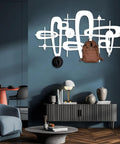 Slick Mid Century Metal Coat Rack With Abstract Wall Hooks Top Shelf Luxury Entryway Decor showcasing brown backpack and hat on wall.