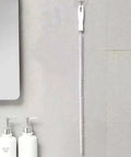 Heavy Duty Flexible Drain Snake Brush For Kicking Clogged Sink And Tub Pipes Clear, reusable tool hanging on wall.