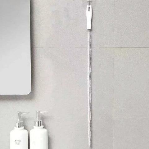 Heavy Duty Flexible Drain Snake Brush For Kicking Clogged Sink And Tub Pipes Clear, reusable tool hanging on wall.