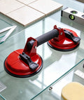 Heavy Duty Vacuum Suction Cups Badass Dual Claw Glass Tile Lifter on glass surface with tools and tile samples.