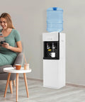 Standing Hot And Cold Water Cooler Dispenser With Top Loading On Demand 5 Gallon Bottle next to woman in living room