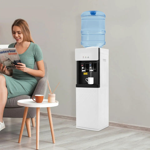 Standing Hot And Cold Water Cooler Dispenser With Top Loading On Demand 5 Gallon Bottle next to woman in living room