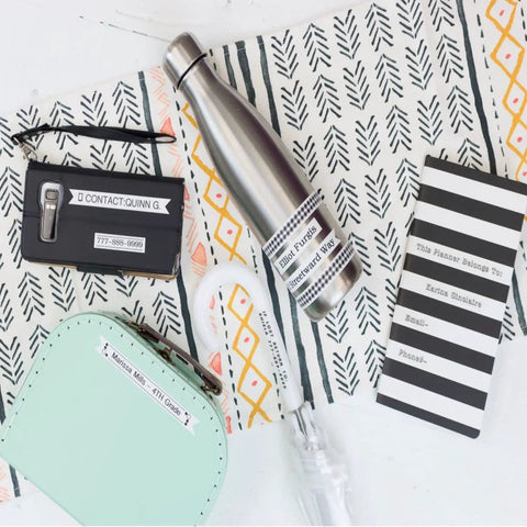 Compact Portable Label Maker Bundle Featuring Qwerty Keyboard Preview Display With Four Laminated Tape Rolls For Quick Home Office Organization Runs Totally Smooth Straight Up A Sweet Deal For Daily Grind And Quick Touch Ups. Labeling various items including a water bottle and planner.