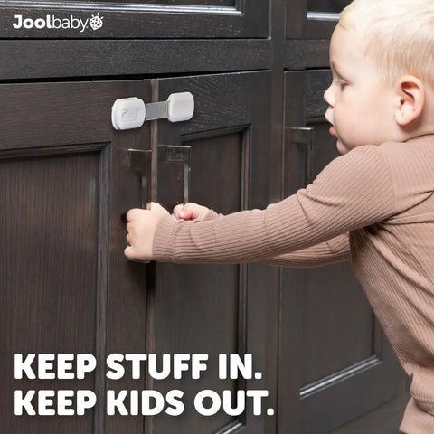 Child attempting to open a cabinet with Four Pack Baby Proof Cabinet, Drawer, Fridge, Toilet And Trash Can Locks with 3M Adhesive.