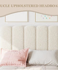 Boucle upholstered headboard in beige with soft texture, paired with a pink decorative pillow, stylish bedroom setup.