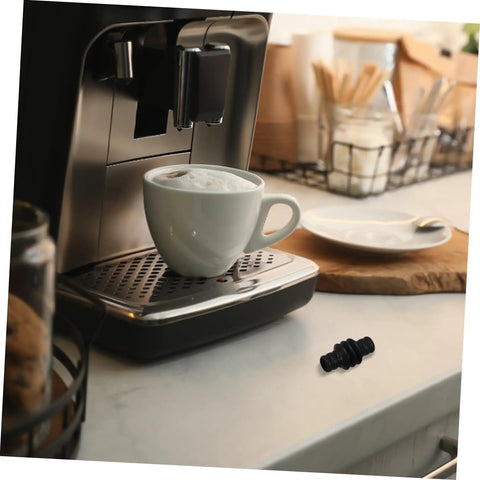 Steam Wand Heat Shield Rubber Sleeve For Espresso Machines on a kitchen counter next to a coffee maker with a cup.