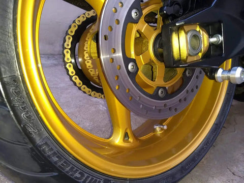 Close-up view of gold motorcycle wheel with attached Angled Valve Stem Set With Pre Applied Threadlocker Nut Forged Aluminum Construction 0.357 Inch (8.3mm) Size Blue Finish Easy Inflation And Tire Pressure Check 2 Pack Fits Standard Rim Openings.