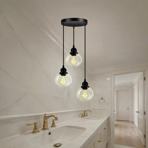 Three Light Pendant Light With Clear Glass Shades, Matte Black Finish hanging above a modern kitchen island