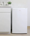 Hella Compact 3.1 Cubic Feet White Upright Freezer With Three Wire Baskets Garage Ready next to a sink in a kitchen setting.