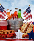12 Pack Small American Flags On Sticks 4x6 Inch Mini US Flags For Outdoor Use with picnic items on table for 4th of July celebration