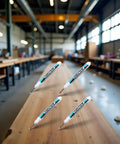 Top Shelf Four Pack Bold White Oil Based Permanent Markers featuring slick quick dry ink on a wooden surface in a workshop.
