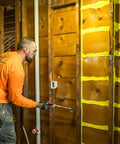 Professional Grade Interior Air Sealant Kicks Drafts To The Curb And Locks Warmth In Along Wall Ceiling Floor Joints Yellow 5 Gallon Big Bucket application on wall framing using caulking tool.
