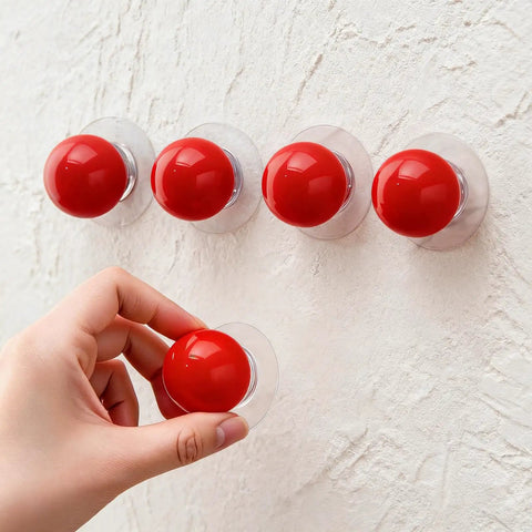 Hand applying Eight Pack Self Adhesive Red Round Cabinet Knobs Peel And Stick Handles for Glass Doors Refrigerators Cabinets