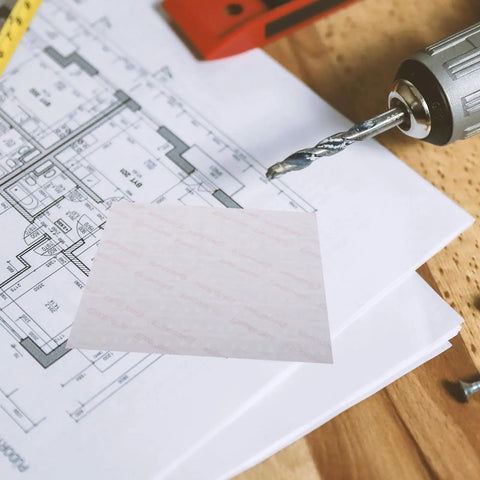Drill on blueprint with blank paper, no clear view of Clear Silicone Furniture Pads 200 Pack No Slip Bumpers For Chair Legs Table Feet Cabinets Doors Floor Protection And Noise Dampening Transparent Glides That Keep Floors Scratch Free And Quiet Movement