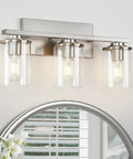 Three Light Brushed Nickel Bathroom Vanity Light Fixture With Clear Glass Shade Over Mirror in modern bathroom setting