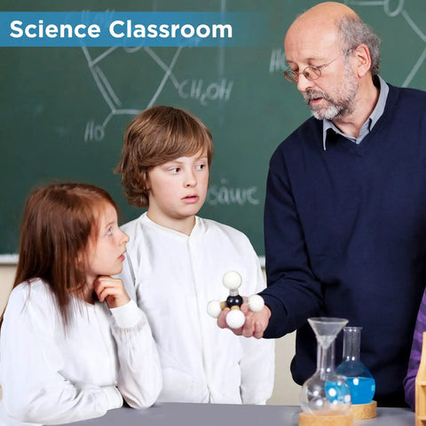 Science teacher showing model to kids in white lab coats with elastic cuffs for home or class experiments.
