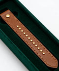 100 Sets Double Cap Leather Rivets And Snap Fastener Kit For Garments, DIY Leathercraft Hardware, Pro Grade Heavy Duty Metal Rivets With Easy Install, Includes Snap Buttons, Perfect For Jackets, Bags, Belts And More. Brown leather strap with gold rivets in green velvet tray