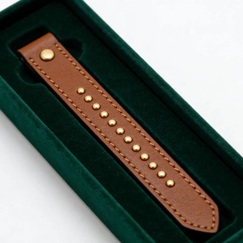 100 Sets Double Cap Leather Rivets And Snap Fastener Kit For Garments, DIY Leathercraft Hardware, Pro Grade Heavy Duty Metal Rivets With Easy Install, Includes Snap Buttons, Perfect For Jackets, Bags, Belts And More. Brown leather strap with gold rivets in green velvet tray