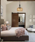 Straight Up Gorgeous Farmhouse Chandelier Featuring Three Woven Rattan Shades hanging in a cozy bedroom with soft lighting.