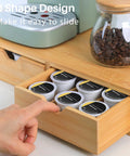 Open drawer with K Cup Pod Holder Drawer Organizer Bamboo Double Drawer Holds Up To 30 Pods showing pods and coffee jar.