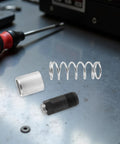 Pro Grade Heavy Duty Floor Jack Replacement Parts Kit With Iron And Rubber Components For Hydraulic Floor Jack Includes Spring Washers And Clips For Secure Assembly And Even Pressure Distribution For Trucks And Cars. spring, washer, and threaded jack part on workbench