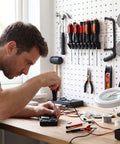 Man using Go To Pegboard Screwdriver Holder and Tool Organizer for garage shop walls, tools neatly arranged on pegboard.