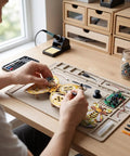 Person assembling Wooden RC Drone Kit For Beginner Friendly Hobbyists, Beechwood Quadcopter With Headless Mode on a desk.