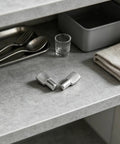 Two nickel-plated metal pegs on a countertop, part of 60 Pack 7Mm Spoon Shape Shelf Peg Pins for Heavy Duty Closet Cabinets.