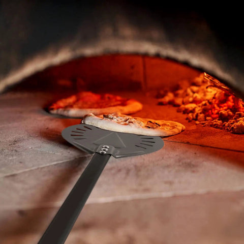 9 Inch Round Perforated Aluminum Pizza Peel With Detachable 40 Inch Handle Lightweight Yet Durable Pizza Turner For High Heat Ovens Outdoor Pizza Oven Accessories For Easy Slide And Turn Pro Grade, shown sliding pizza in oven.