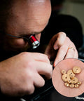 Person examining brass clock hand nut kit with 12 pieces in 5mm, 6mm, and 10mm sizes