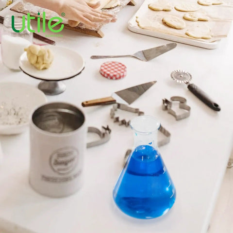 A blue liquid in a 50ml narrow mouth borosilicate 3.3 glass Erlenmeyer flask with baking tools in the background.