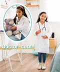Girl wearing 20 Pack Kids Lab Coats White Unisex Science Doctor Costume for Halloween School Play, holding teddy bear and stethoscope.