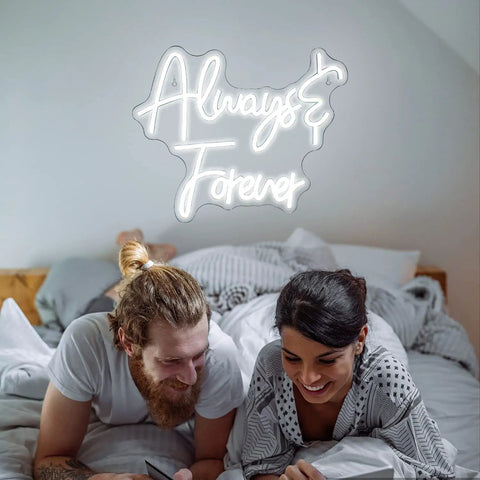 Couple in bedroom under 'Always & Forever' neon sign, white bedding, cozy decor, USB-powered wall art, romantic theme