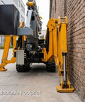 Adjustable Boom Hydraulic Concrete Placer For Floor Slabs Bridges And Warehouse Floors A Real Workhorse For Multi Purpose Construction Projects With Smooth Placement And Easy Operation On Big Jobs, side view by brick wall