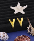 Chunky Gold Plated Earrings for Women, 18K Gold Plated Stainless Steel V Shape Heart Shell Studs displayed with seashells
