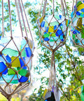 Colorful glass mosaics hanging from strings showcasing Clear Multipurpose Adhesive For DIY Projects With Low Odor Self Leveling And Flexible Bond UV Resistant Paintable Washer Dryer Safe Acid Free Formula For Crafts Jewelry Making Home Repairs And Hobby Projects.